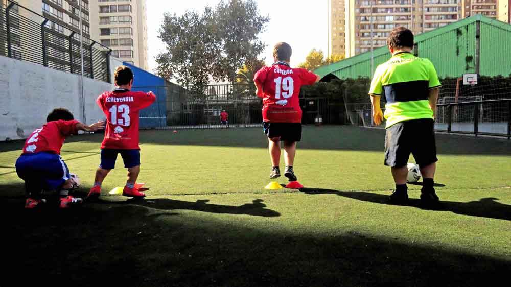 Algunos jugadores de la selección chilena de fútbol talla baja entrenan en una cancha de pasto.