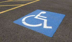 Foto de un estacionamiento azul con el símbolo de la discapacidad, indicando que está reservado