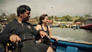 n joven en silla de ruedas junto a la fundadora del centro de buceo, navegando en un bote.