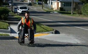 Un ingeniero cruza la calle en una silla de ruedas.