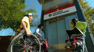 Foto donde aparece una persona en silla de ruedas esperando el ascensor para entrar al Metro de Santiago.