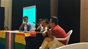 Foto de cuatro personas en situación de discapacidadexponiendo en un seminario LGBTI en España.