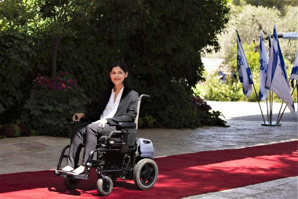 Una mujer en silla de ruedas sobre una alfombra roja