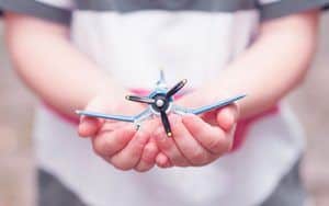 Imagen manos sosteniendo un avión de juguete