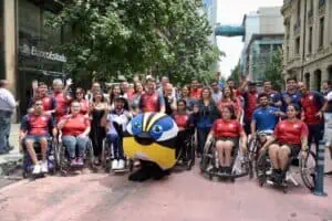 Foto donde aparecec un grupo de deportistas paralímpicos, en su mayoría en silla de ruedas, posando para la foto junto a autoridades y la mascota de los juegos panamericanos.